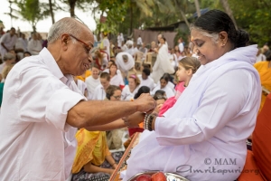 Atando Rakhi en la mano de Amma